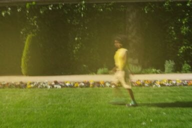 An out-of-focus person walking across grass symbolizing the nature of complex PTSD (CPTSD)